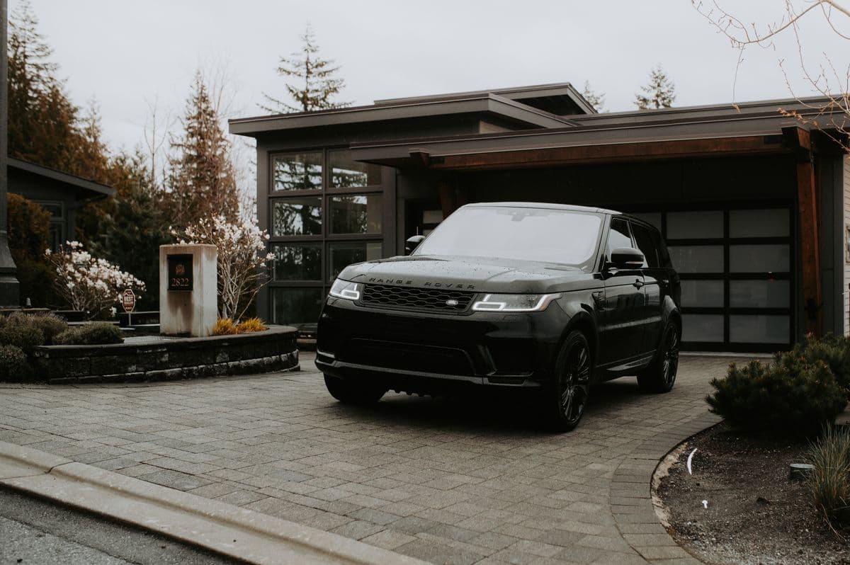 Glossy dark SUV parked in a home driveway in the evening light